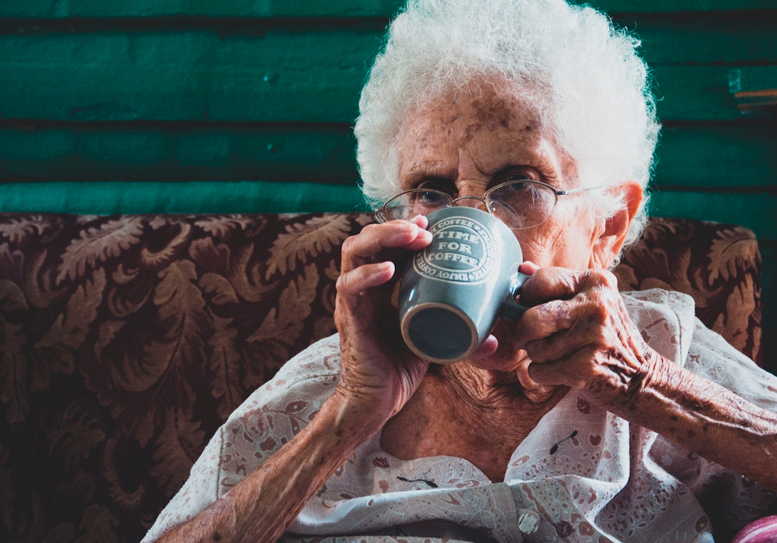 man drinking from white ceramic mug