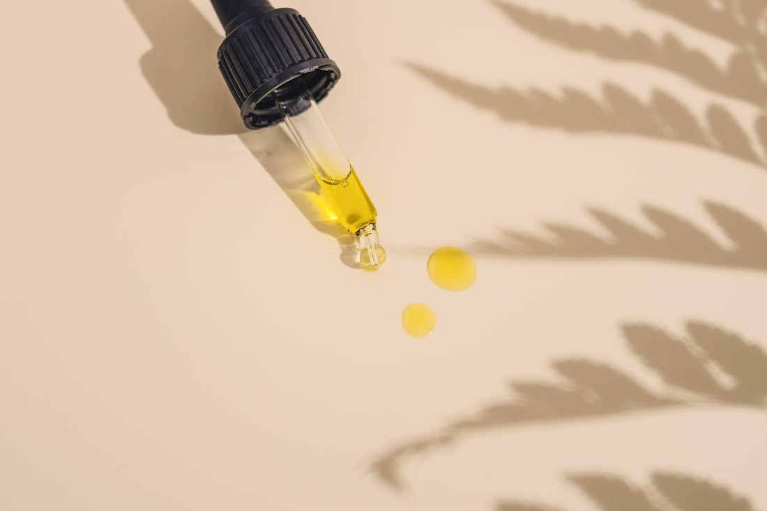Skintastic Cosmeceuticals Australia Close-up of a dropper with yellow skincare oil and drops on a beige surface, exploring the evolution of skincare through the ages