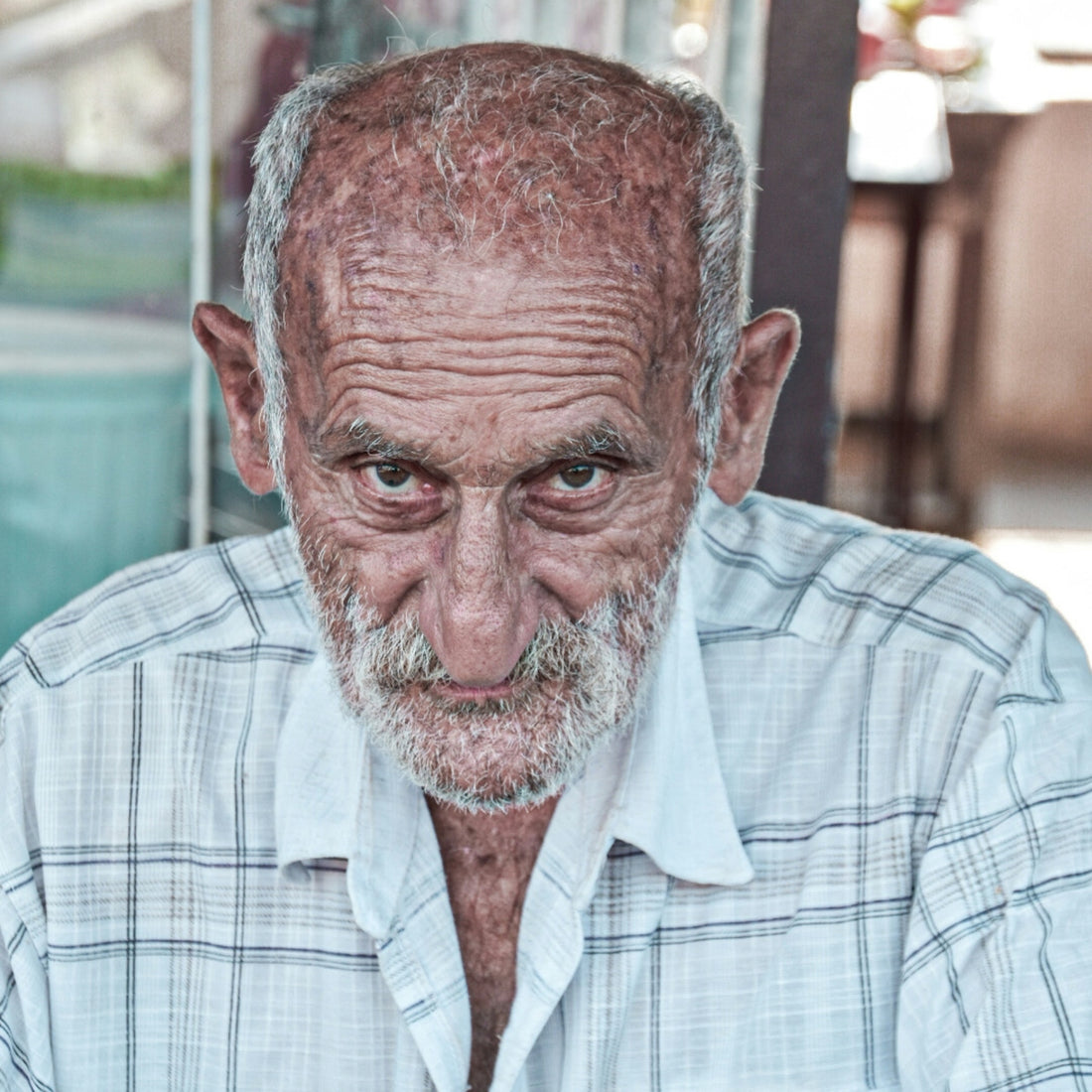an old man with a white beard is looking at the camera