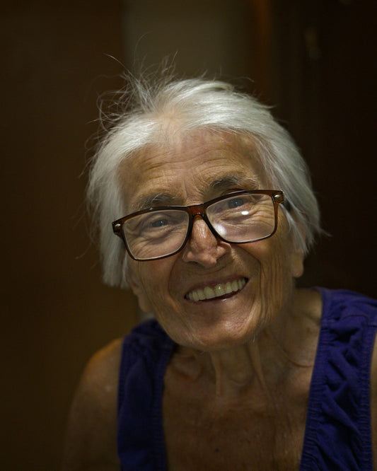 An older woman with glasses smiling at the camera