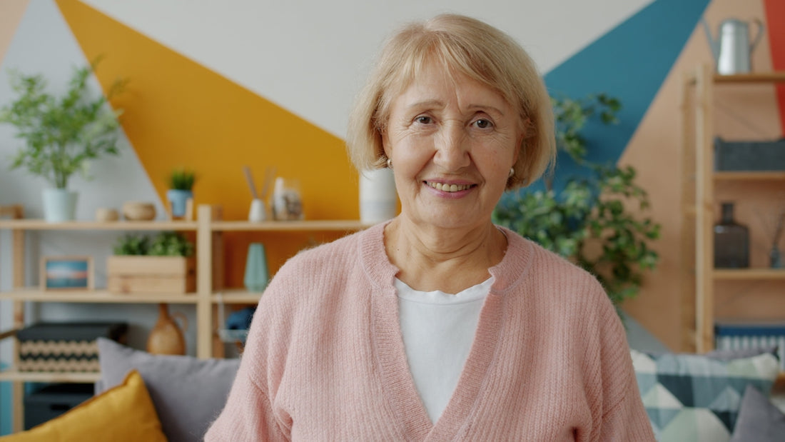Elderly woman smiling in a living room.