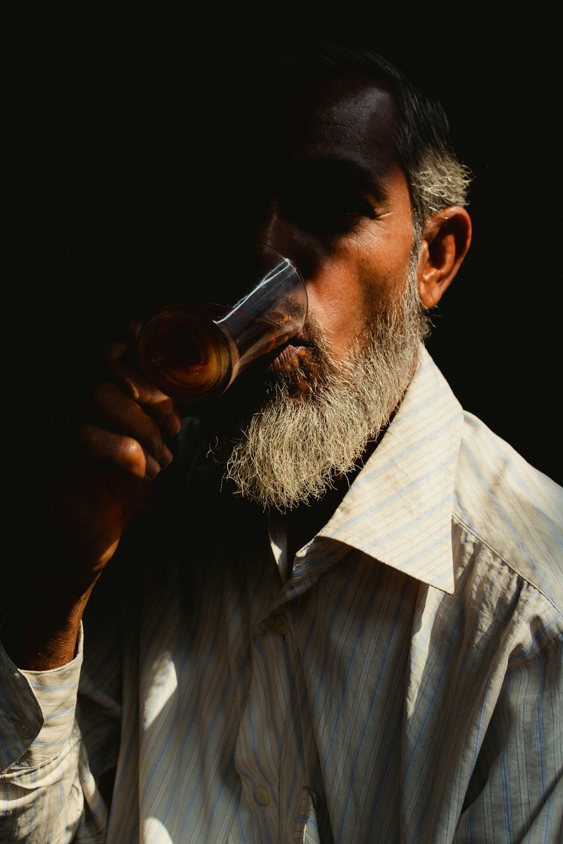 a man with a beard drinking from a glass