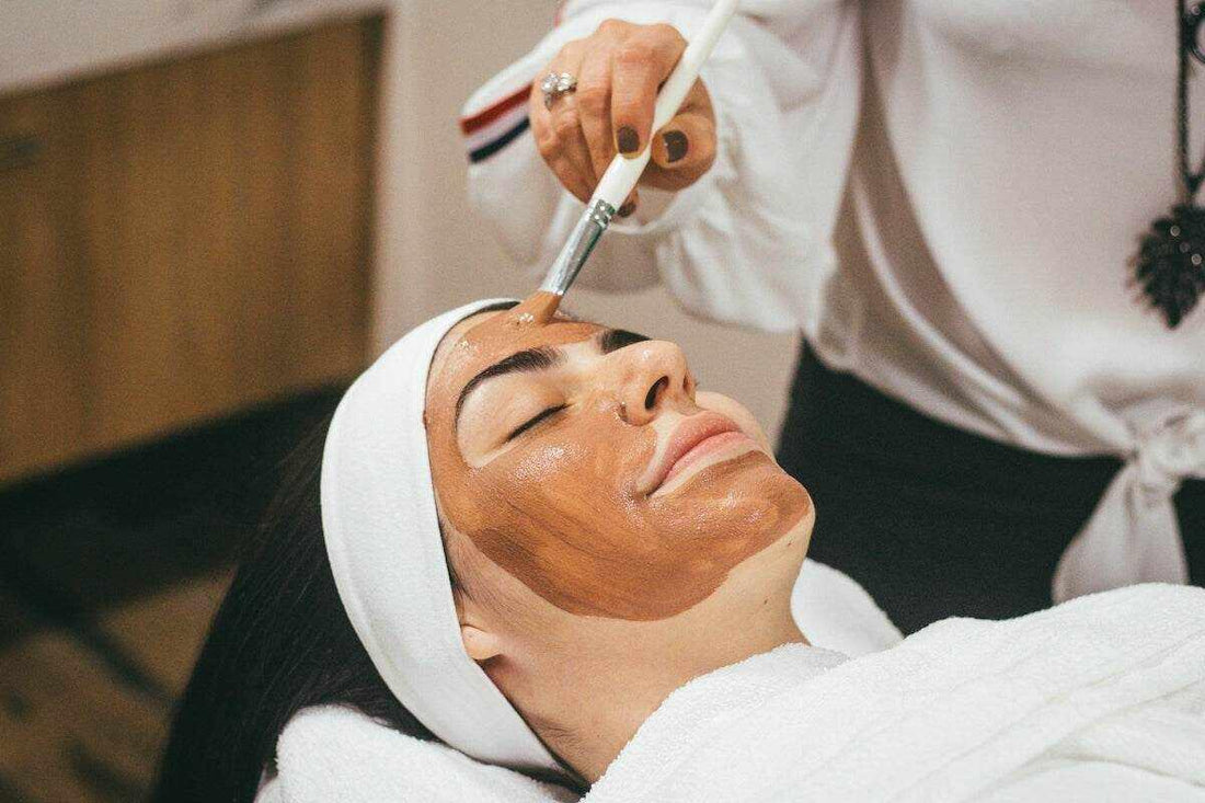A woman receiving a facial treatment showcasing the difference in chemical vs physical exfoliants