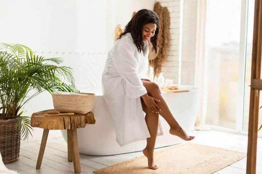 Woman applying lotion in a spa-like setting, showcasing the best retinol products Australia for skincare