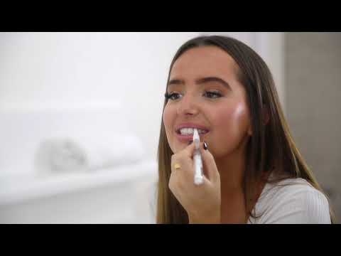 Woman applying gel pen from a Carbamide peroxide teeth whitening kit for a brighter smile at home